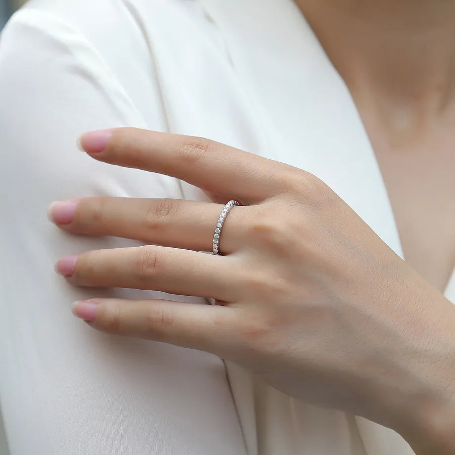 Hand wearing a silver ring on a white background