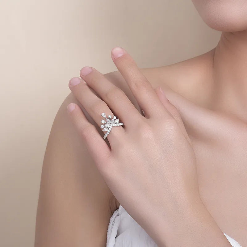 Close-up of a hand wearing a silver ring with a diamond on a beige background