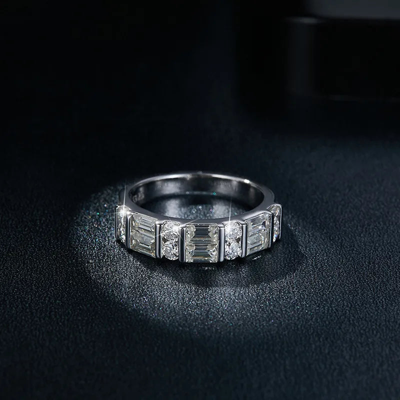 Silver ring with diamond accents on a dark surface